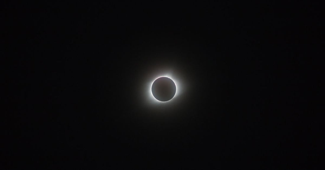 Captivating image of a solar eclipse with a glowing corona against the dark sky.